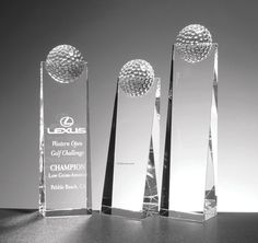 three crystal award trophies sitting on top of a table next to each other in front of a black and white background