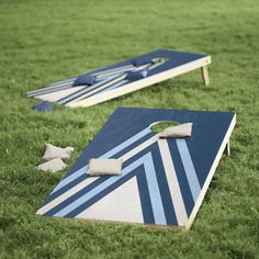 two cornhole boards sitting on top of green grass