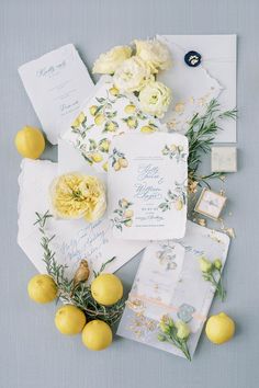 the wedding stationery is laid out with lemons, flowers, and other items