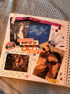 an open notebook with pictures and stickers on it sitting on top of a bed