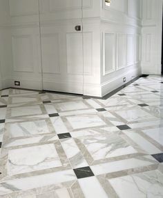 a white and black tiled floor in a room with two doors on either side of it