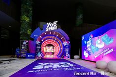 the entrance to yoo space is lit up with purple and blue lights at night