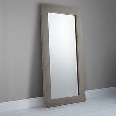 a mirror sitting on the floor next to a wall