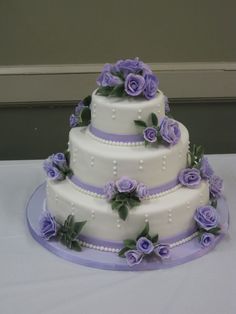 a three tiered wedding cake with purple flowers