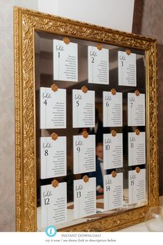 a gold framed mirror with place cards on the front and back of it, along with a table number for each guest