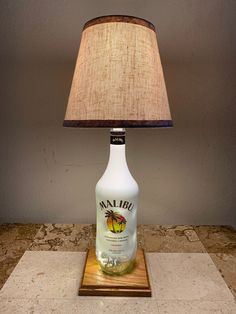 a lamp that is sitting on top of a table next to a bottle with a label on it