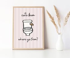 a white vase sitting next to a wall with a poster on it that says cute bum where ya found?