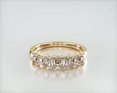 a yellow gold wedding ring with five stones on the side and two rows of diamonds in the middle