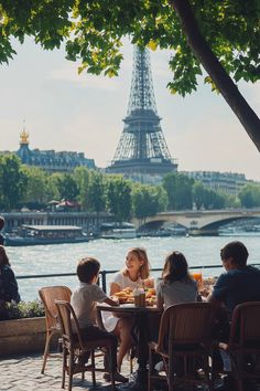 some people sitting at a table with food in front of the eiffel tower