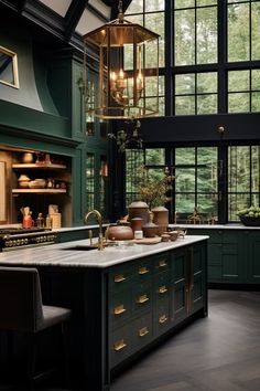 a large kitchen with green cabinets and an island in the middle, surrounded by windows