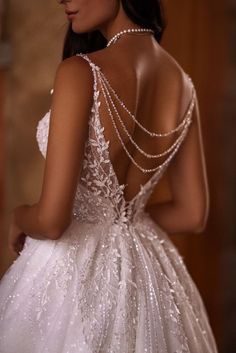 a woman in a wedding dress with pearls on her back