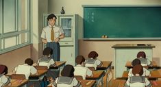 a man standing in front of a class room full of kids sitting at desks