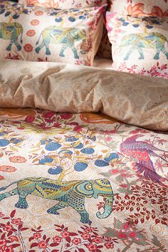 the bed has an elephant print on it and is made up with many different colors