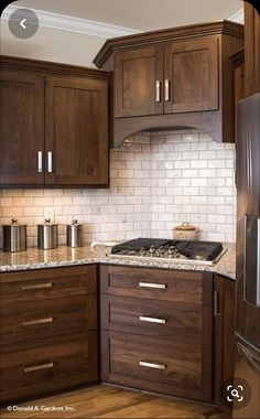 a kitchen with wooden cabinets and marble counter tops