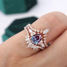 a woman's hand holding a ring with a blue and white stone in it