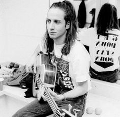 a man sitting on a counter holding a guitar