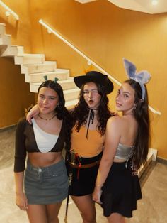 three young women dressed up in costumes posing for the camera with their hands on their hipss