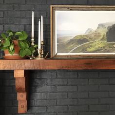 there is a painting on the mantle next to candles