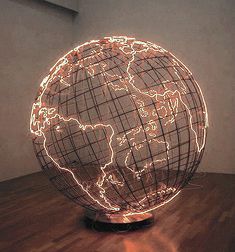 an illuminated globe sitting on top of a wooden table