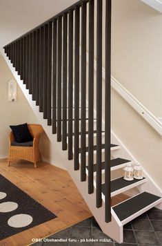 a chair sitting under a stair case next to a set of black and white stairs