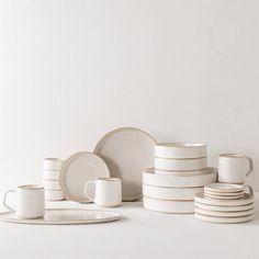 a stack of white plates and cups sitting next to each other