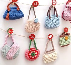 crocheted purses hanging on a clothes line with price tags attached to them