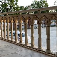 a car is parked on the side of a building next to some pillars and railings