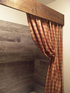 the curtain is pulled back from the wooden beam above the bathtub in this bathroom