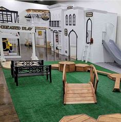 an indoor play area with benches, slides and other items on display in the background