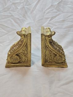 two golden bookends are sitting on a white sheet