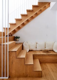 a white couch sitting under a wooden stair case