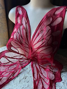 a pink butterfly shawl on a mannequin