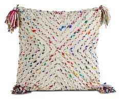 a white pillow with multicolored beads and tassels on the front side