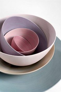 three plates stacked on top of each other with different colored bowls in the same bowl