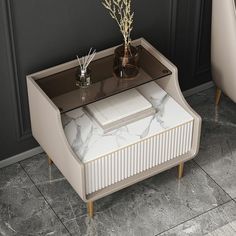 a marble topped coffee table with two vases on it and a plant in the middle