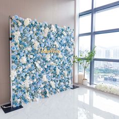 the wall is decorated with blue and white flowers in front of a large glass window