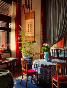 a dining room filled with lots of furniture and flowers in vases on the table