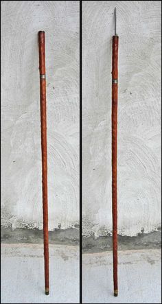 two wooden poles are standing next to each other in front of a white stucco wall