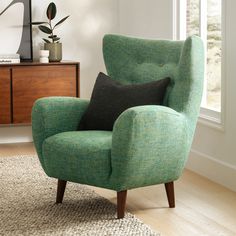 a green chair sitting in front of a window