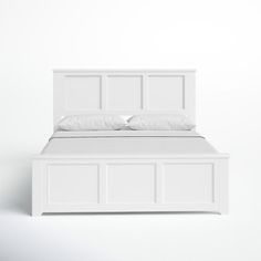 a white bed with two pillows on top of it