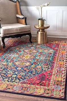 a colorful area rug with an ornate design on the floor and a chair next to it