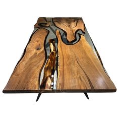 a table made out of wood and glass with a snake on it's side