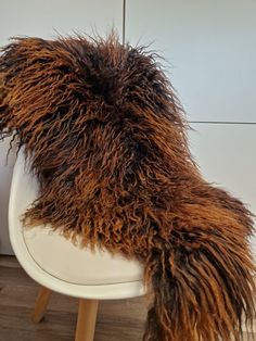 a furry chair cushion sitting on top of a white chair