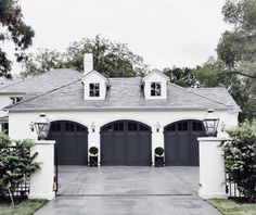 a white house with black garage doors and windows