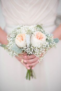 a bride holding a bouquet of flowers in her hands