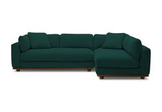 a large green couch sitting on top of a white floor