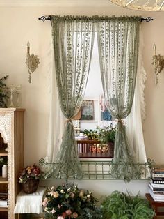 a living room filled with lots of furniture and flowers on the window sill next to a book shelf