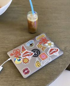 a laptop computer sitting on top of a wooden table next to a cup of coffee