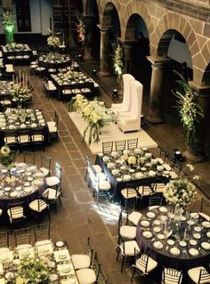 tables and chairs are set up in an old building for a formal dinner or function