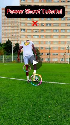 a man riding a bike on top of a lush green field next to a tall building